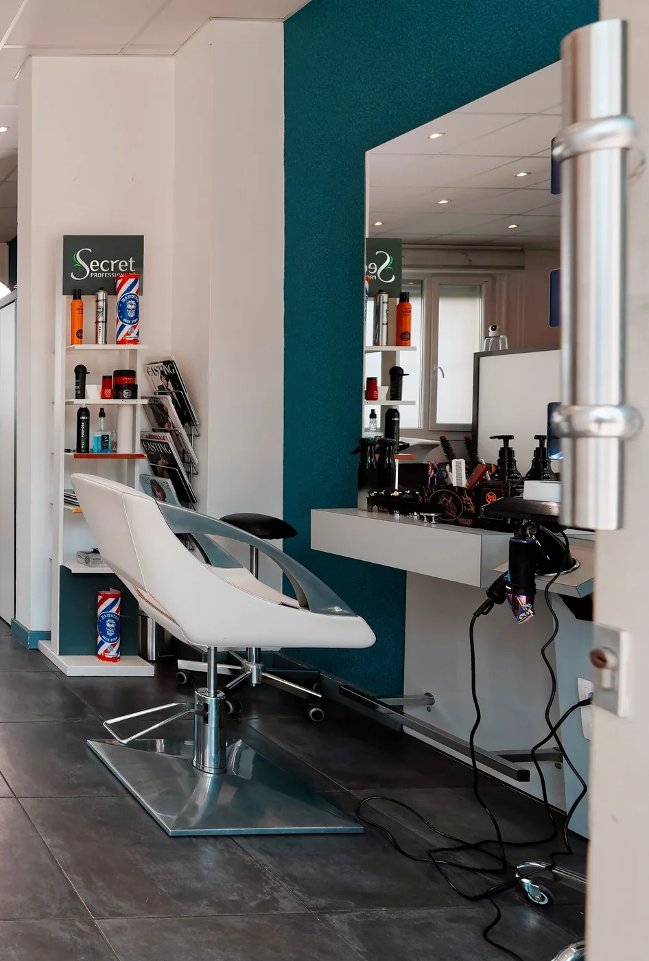 Intérieur du salon Barber Shop 59 à Dunkerque, mur teal et fauteuil de coiffe