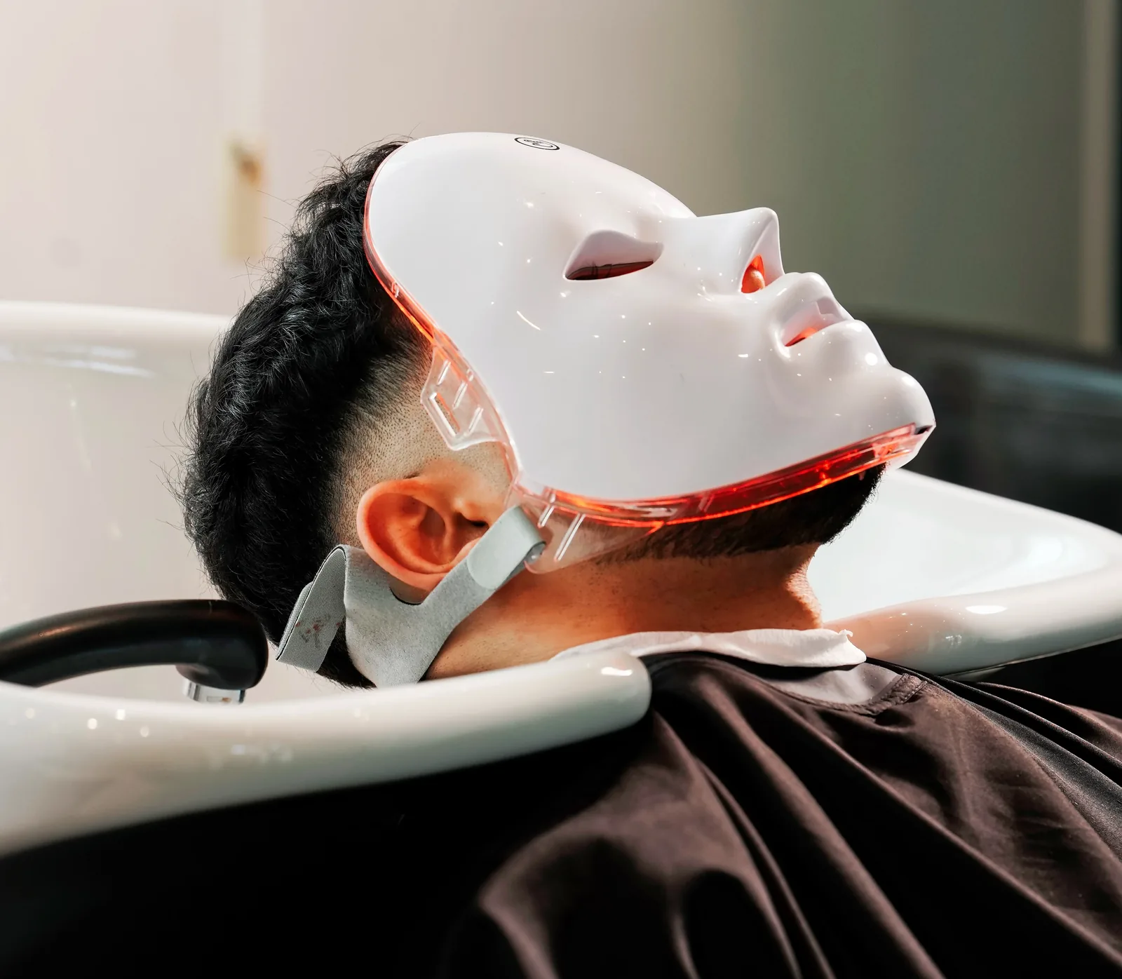 Client sous masque LED pendant un soin visage au Barber Shop 59